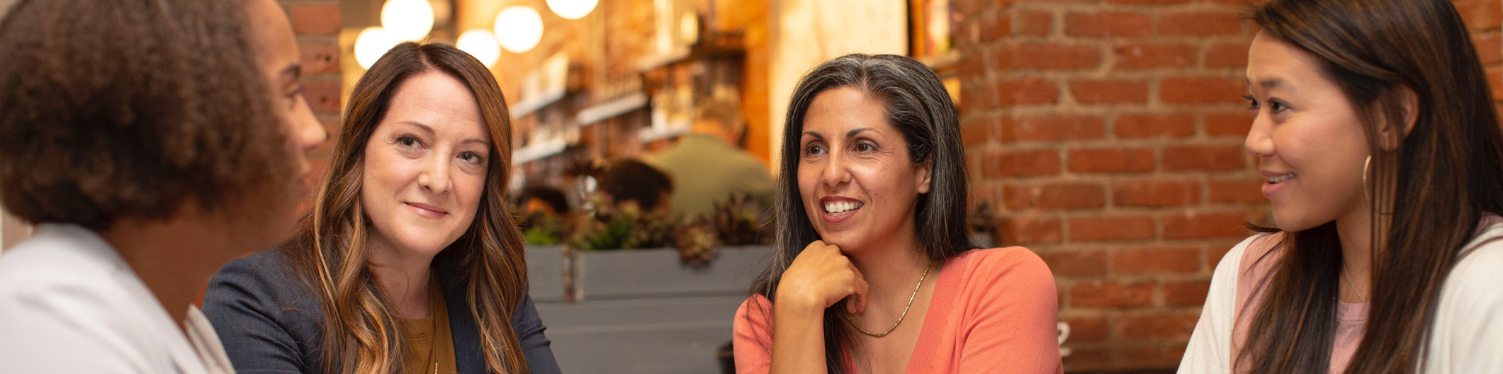 Four women talking in a coffee shop