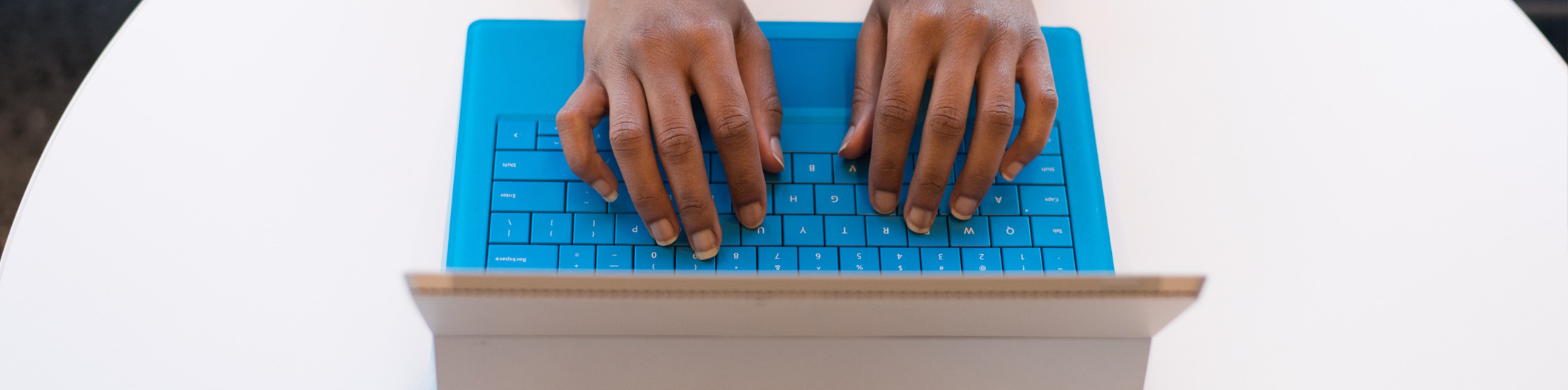 woman typing on a blue keyboard